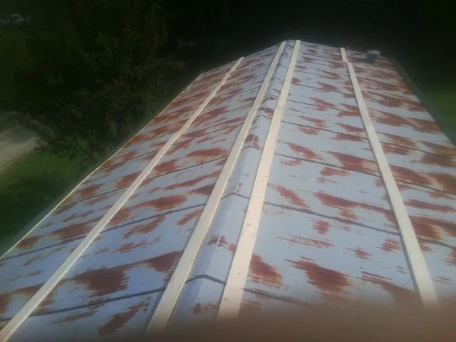Rusted metal roof panels with new wood purlins before replacement — Storm Damage Roof Repair in Willow Springs by Roofing Brothers