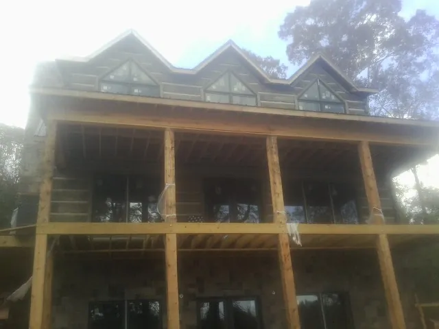 Dormers and porch framing on a large log home under construction — Roof Coating work by our crew in Willow Springs